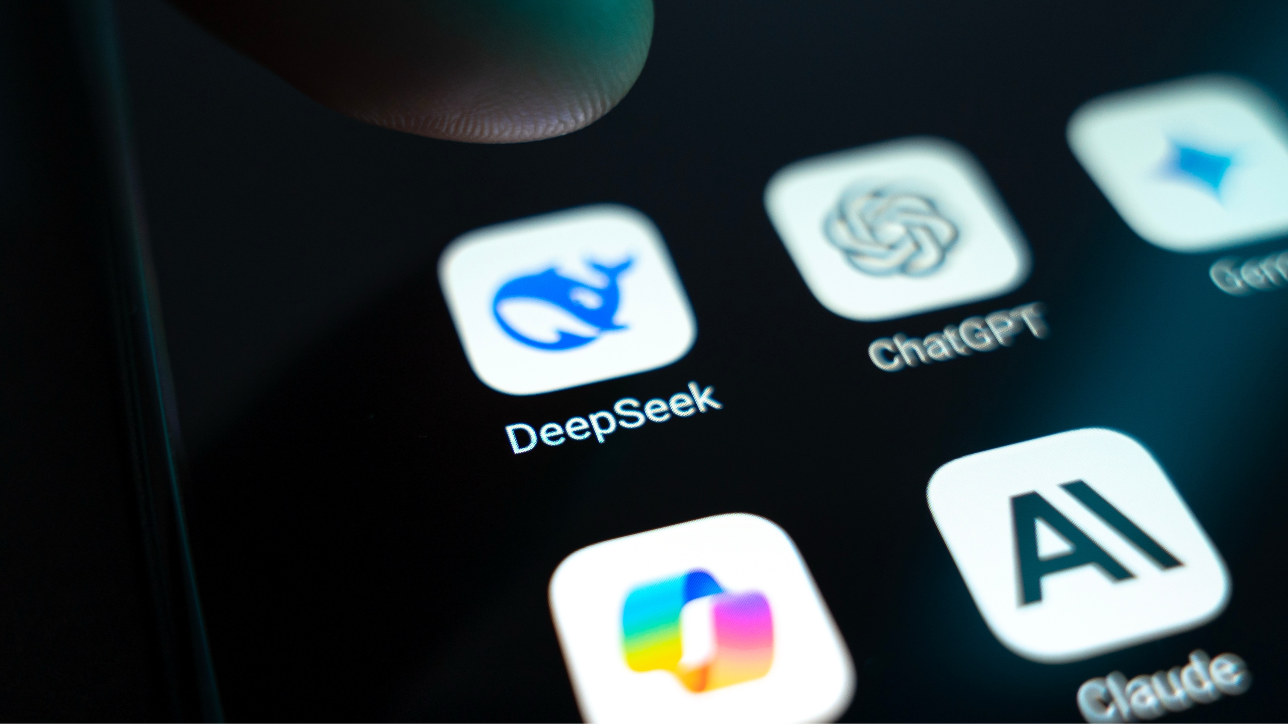 Close-up of a smartphone screen showing AI app icons, including DeepSeek, ChatGPT, and Claude.