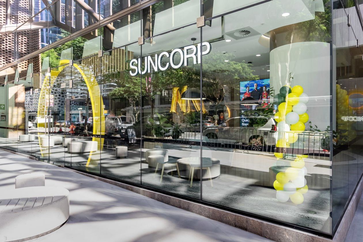Suncorp Group retail front showing a glass wall with the Suncorp logo.