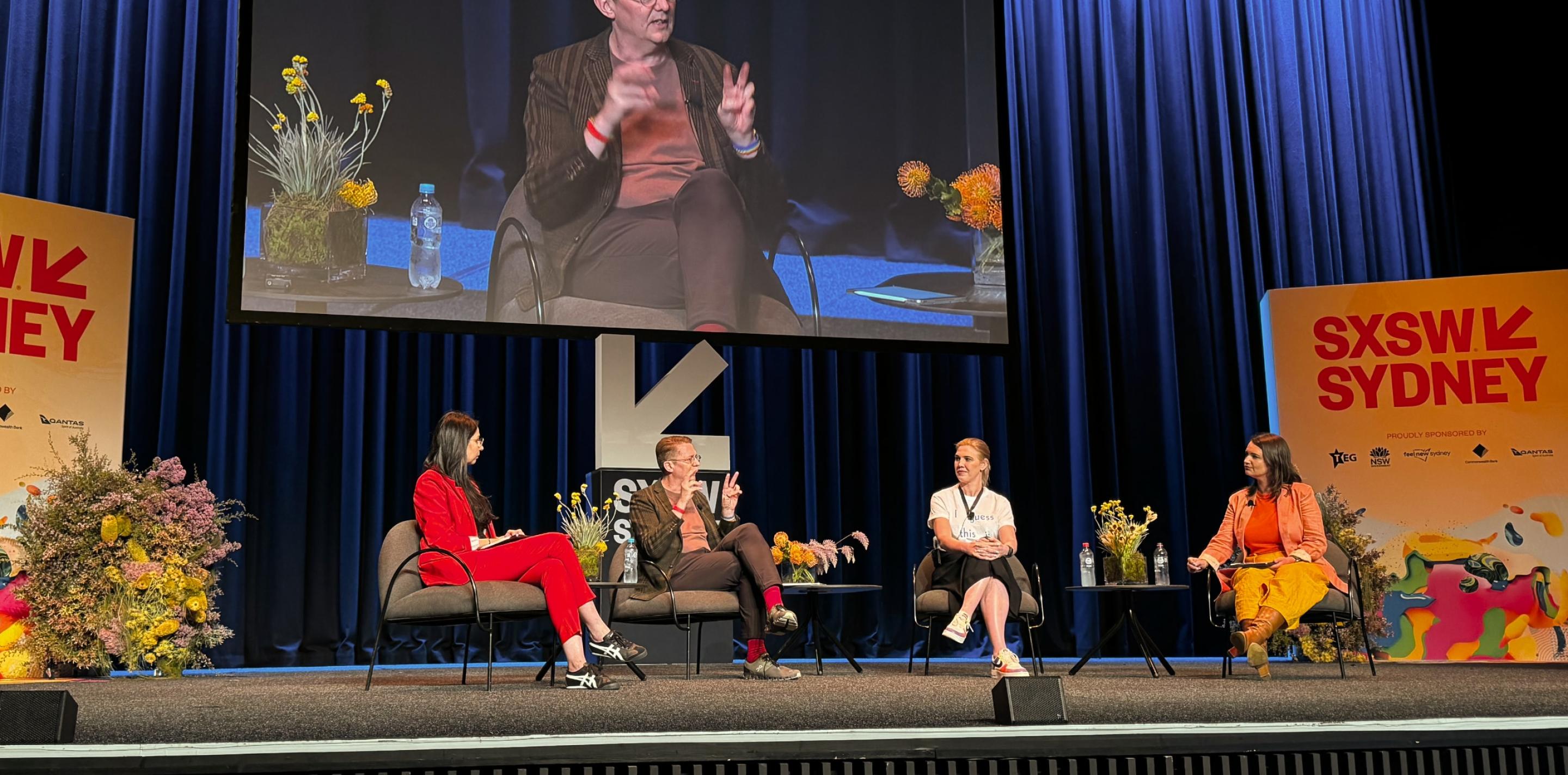 A panel discussion at SXSW Sydney 2023 on the topic of AI fluency and future job impacts, featuring four diverse panelists seated on stage.