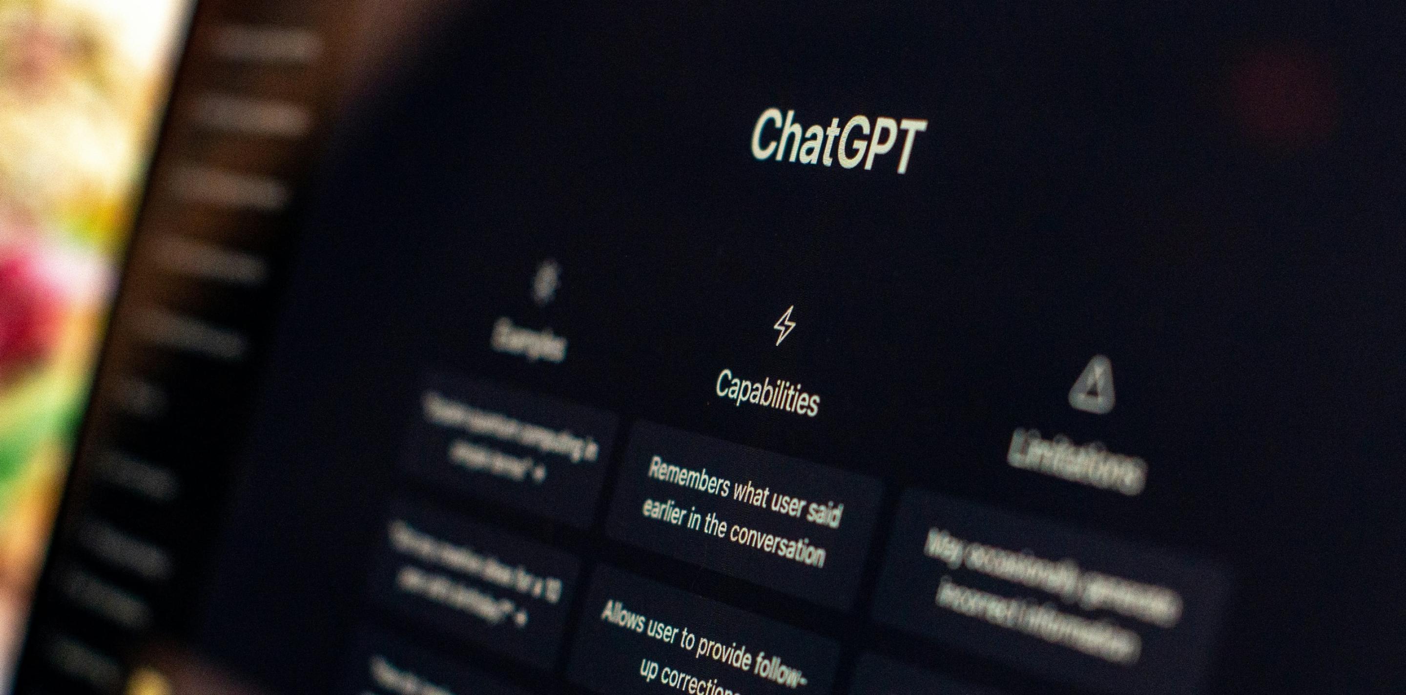 ChatGPT welcome screen on a dark monitor, showing Capabilities and Limitations columns.