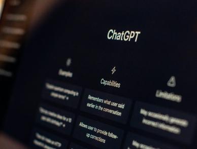 ChatGPT welcome screen on a dark monitor, showing Capabilities and Limitations columns.